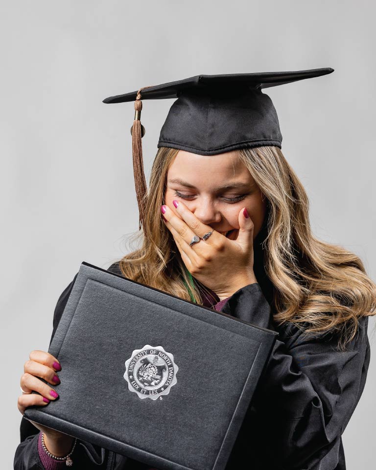 smiling person in graduation cap and gown